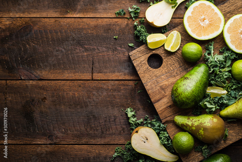 Green smoothie ingredients and chopping board on wooden table
