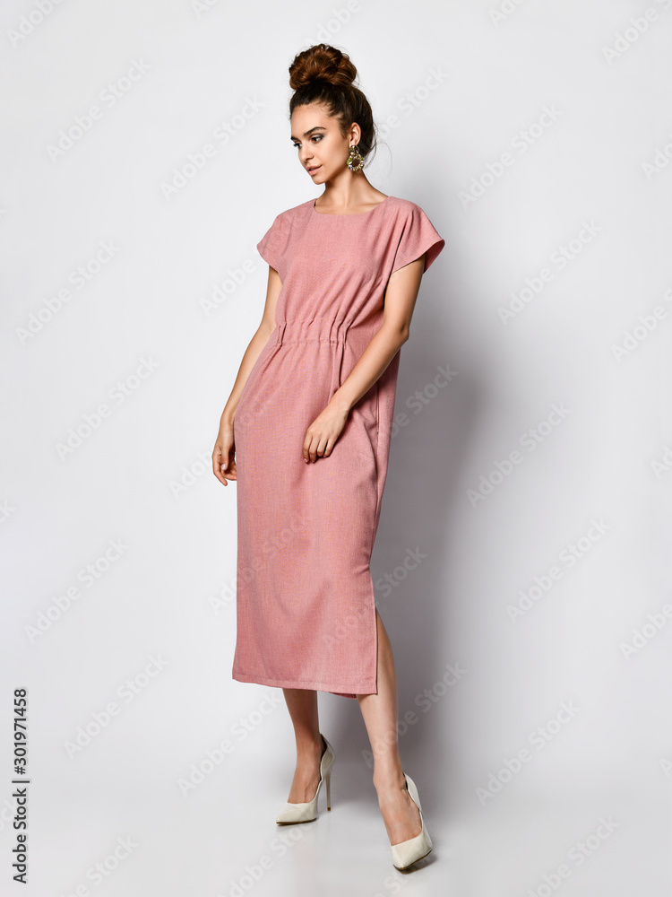 Slim curly female model in a silk pale pink dress looking at the camera in  full growth. Cute girl in romantic clothes is going on a date фотография  Stock | Adobe Stock