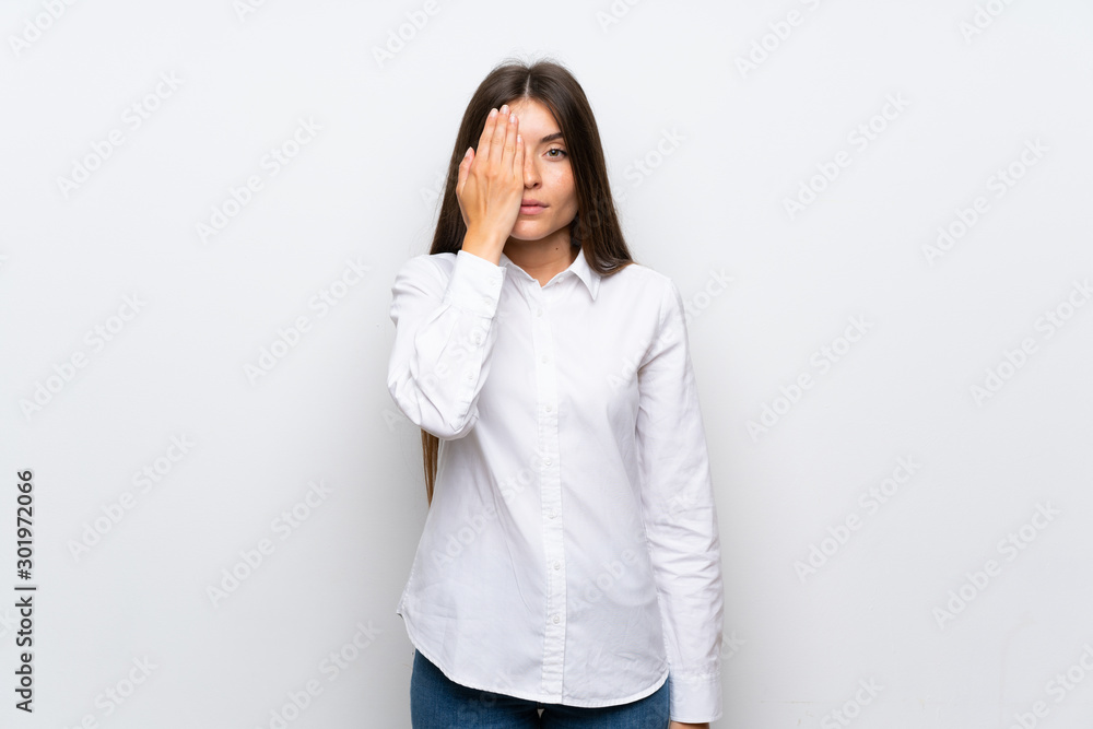 Young woman over isolated white background covering a eye by hand Young woman over isolated white background covering a eye by hand
