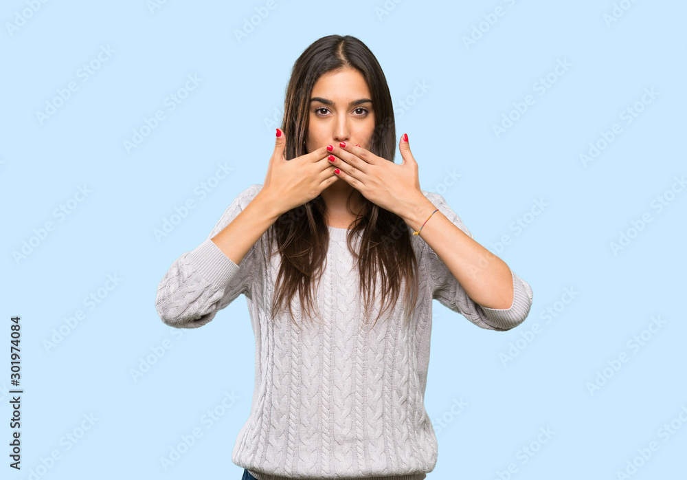 Young hispanic brunette woman covering mouth with hands over isolated background Young hispanic brunette woman covering mouth with hands over isolated background