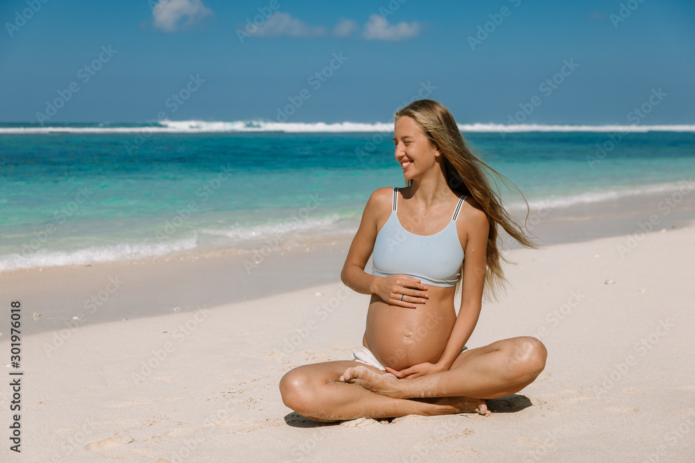 Pregnant woman expecting baby at tropical beach