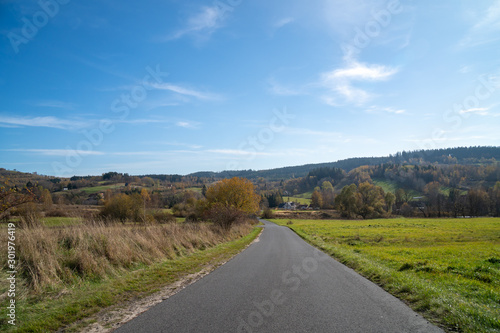 Panoramic view of fields near Gluszyca and Walbrzych. Autum sunny weather, vivid colors. Tarmac road in the middle