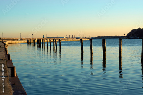 Dock pillars with reflection at sun set, romantic vacation at the beach, German getaway © peter