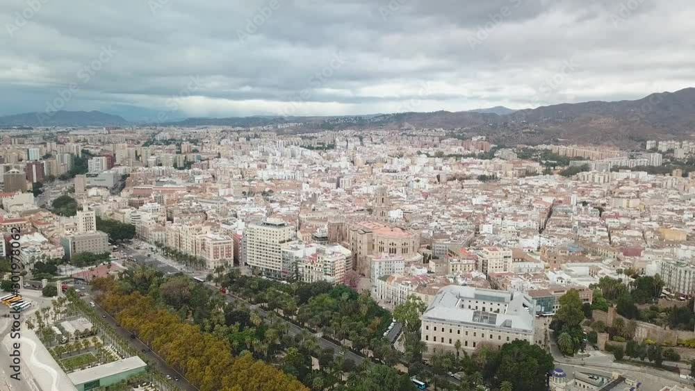 Beautiful panoramic aerial view of Malaga City. View of the Cathedral of Malaga and Historical centre. Mountains in Background Port of Malaga and famouse Dock One. Cloudy day, beautiful sky colours. 