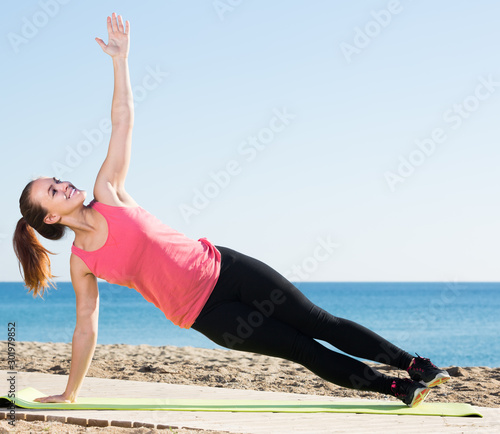 cheerful girl exercising on exercise mat outdoor