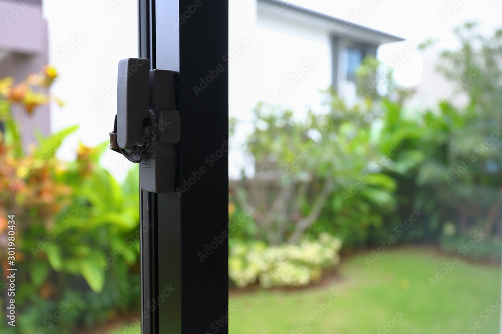 security lock on glass window with green garden outside view of home security lock on glass window with green garden outside view of home