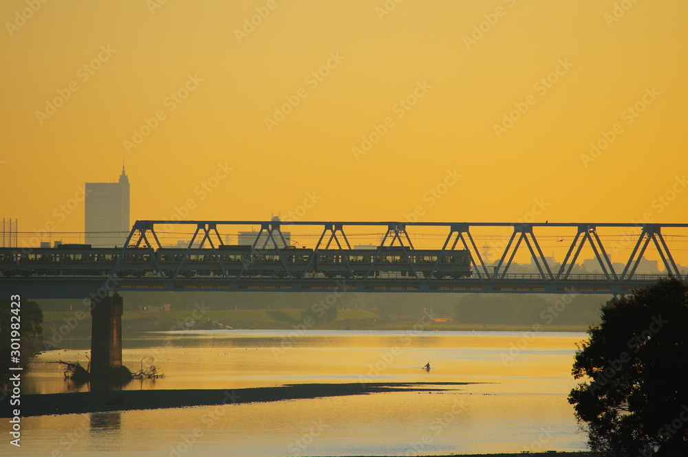 多摩川原橋から望む朝焼けと京王線多摩川橋梁 StockFoto Adobe Stock