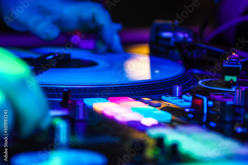 DJ playing music at the club on vinyl players, selective focus, DJ hands photo
