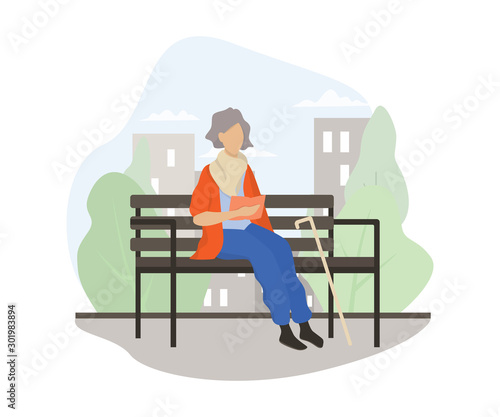 Old lady sitting on the bench in the park and reading a book.