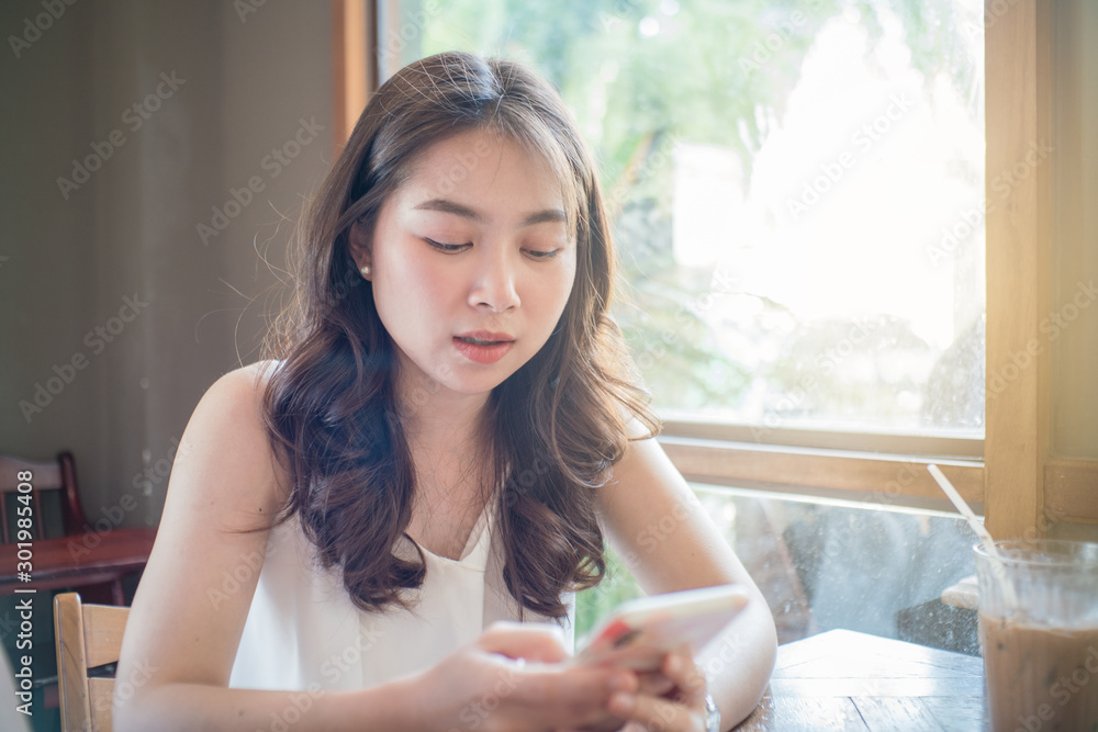 Business asian women use smartphone sitting in coffee shop Business asian women use smartphone sitting in coffee shop