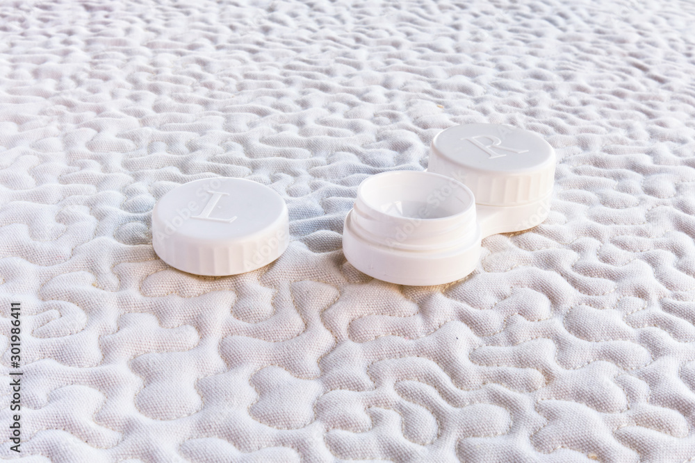 Opened contact lens case, on white fabric. Opened contact lens case, on white fabric.