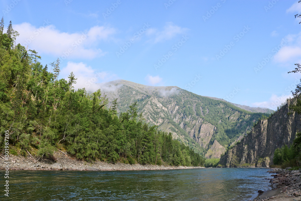 Mountain river landscape in Siberia - stream of a mountain river running between mountains in summer. River Oka Sayan, East Saiyan, Russia.