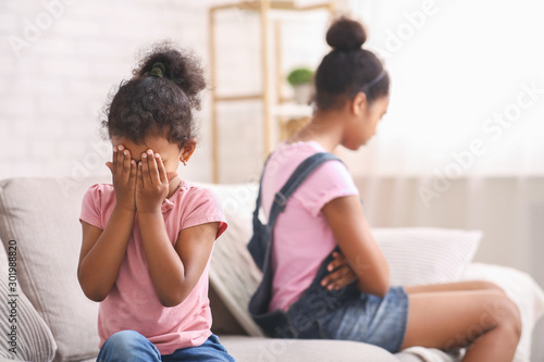 Little african girl crying after quarrel with her elder sister