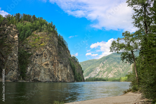 Foto Mountain river landscape in Siberia - stream of a mountain river running between mountains in summer