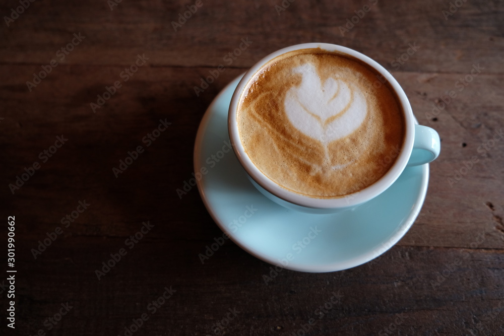 Cappuccino or latte with frothy foam, blue coffee cup top on wooden coffee shop background Cappuccino or latte with frothy foam, blue coffee cup top on wooden coffee shop background