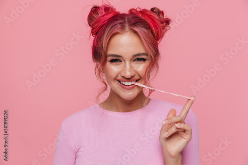 Fotografie Portrait of happy young woman with colored hair stretching chewing gum