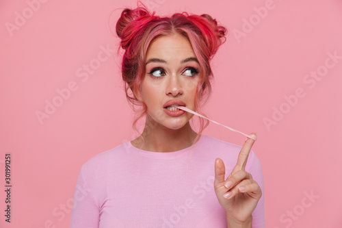 Fotografie Portrait of stylish young woman with colored hair stretching chewing gum