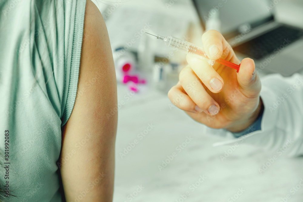 Doctor vaccinating patient in clinic Doctor vaccinating patient in clinic