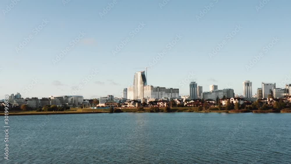 Drone flying above beautiful autumn lake and modern futuristic city skyline scenery, seagulls fly very close to camera. Drone flying above beautiful autumn lake and modern futuristic city skyline scenery, seagulls fly very close to camera.