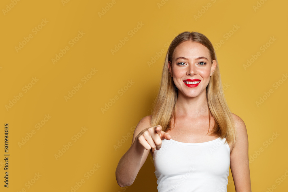 Pretty woman pointing on bright yellow background Pretty woman pointing on bright yellow background