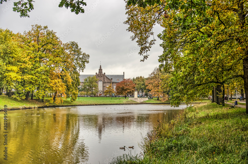 Zwolle, the Netherlands, November 11, 2019: view across the town's ramparts canal towards Ter Pelkwijk park and Plantage church on a cloudy day in autumn