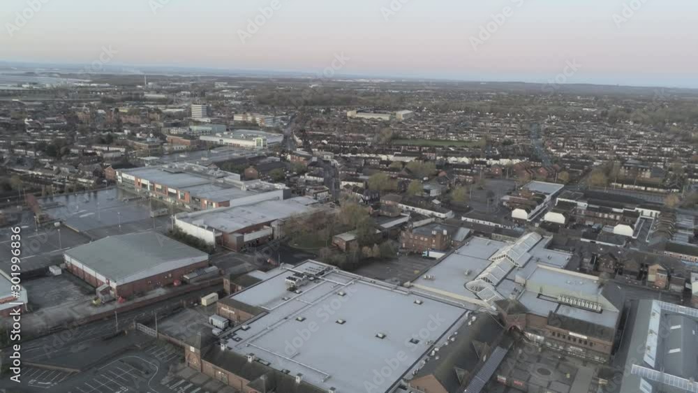 Aerial view above Widnes, Cheshire town urban warehouse shopping retail centre. Pull back above retailers car park & warehouse buildings. Aerial view above Widnes, Cheshire town urban warehouse shopping retail centre. Pull back above retailers car park & warehouse buildings.