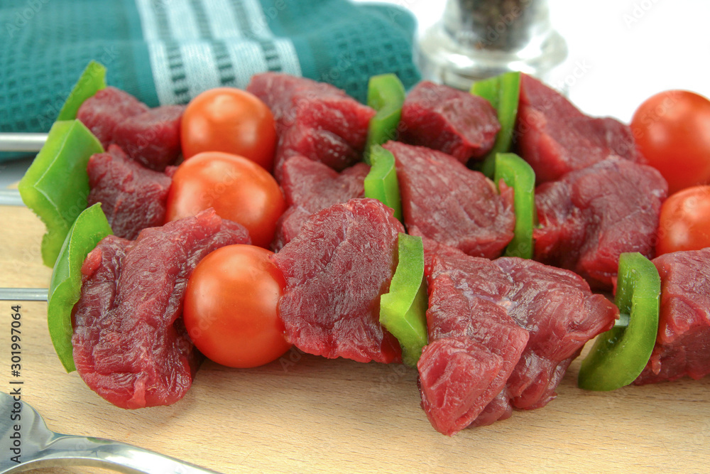 skewers of beef, pepper and raw tomato on a white background skewers of beef, pepper and raw tomato on a white background