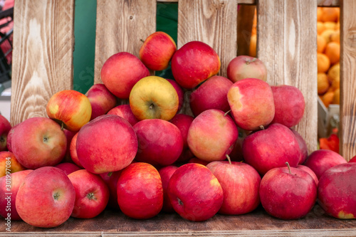 fresh ripe organic apples on a wooden background on a street farm market