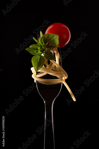 spaghetti with tomato and basil on fork