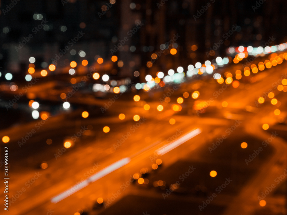 Obraz premium Blurred lights of night city and motion traffic on a highway.