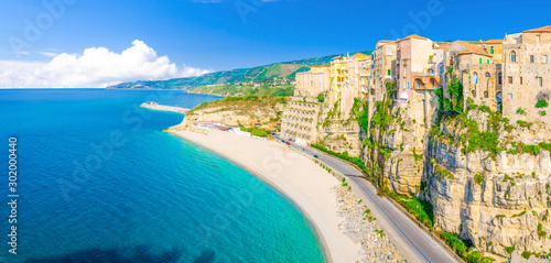 Aerial panoramic view of Tropea town and beach coastline of Tyrrhenian Sea with turquoise azure water, colorful houses buildings on top of high big rocks, road along sea, Calabria, Southern Italy photo