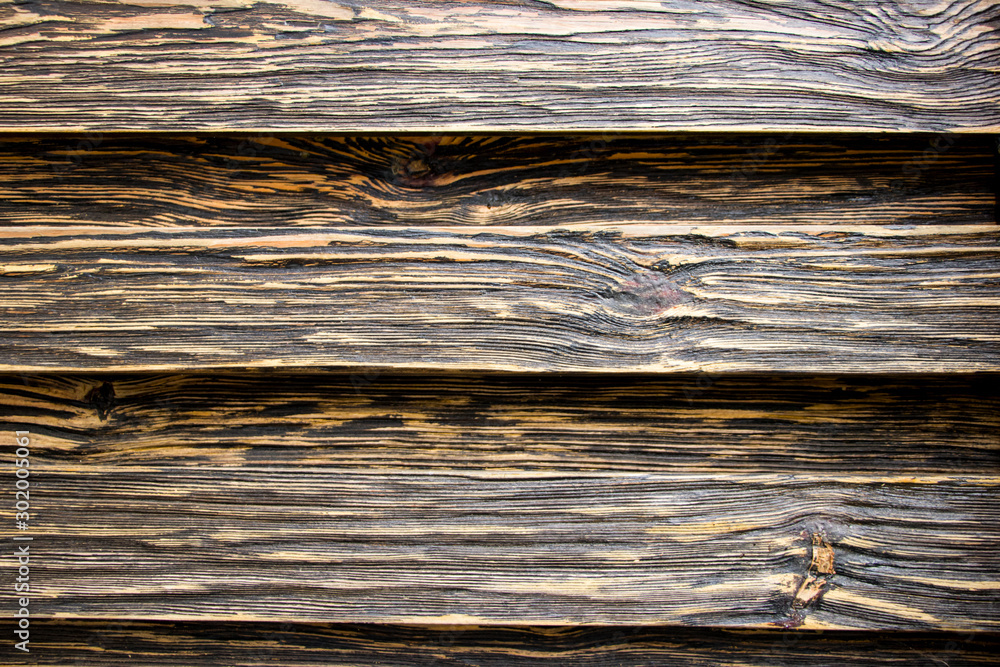 Fototapeta premium Aged wood texture. Boards are black and brown. Artificially aged wood. Deep texture. The concept of an old tree.