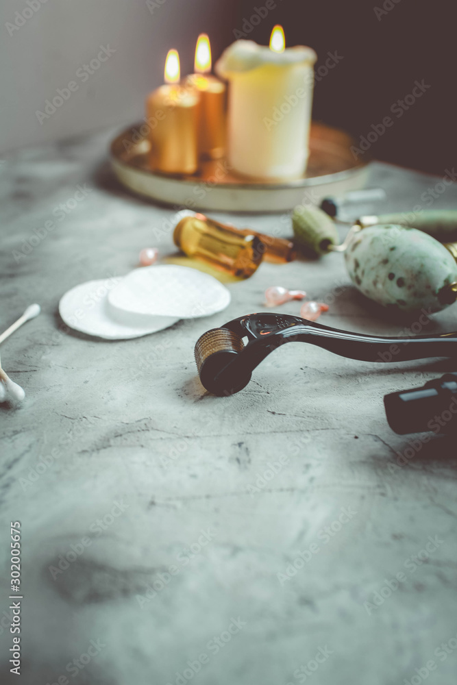 Fototapeta premium Dermaroller and serum next to an anti aging face cream Beauty industry Close-up Dermaroller for medical micro needling therapy Derma roller mesoroller for mesotherapy Copy space Selective focus