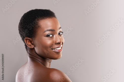 Half-turned african woman with perfect skin and beautiful smile