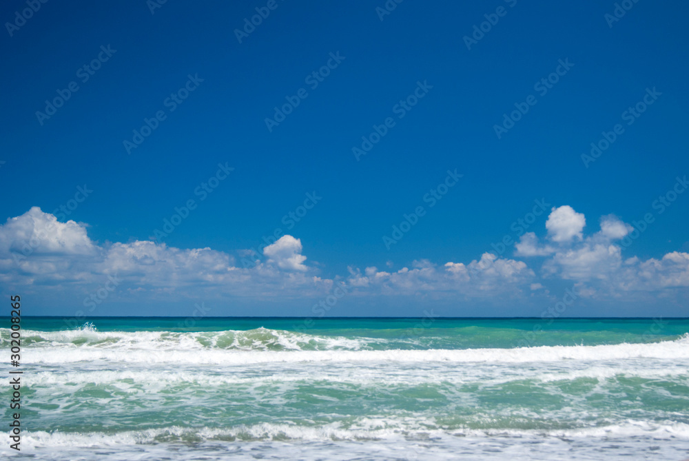 Beautiful landscape/seascape of green ocean and blue cloudy sky in summertime. Ocean, sea, vacation and summer concept.