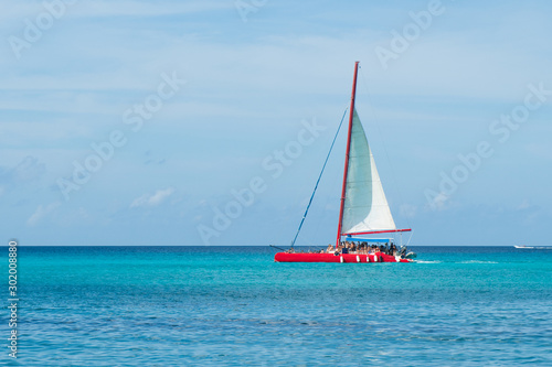 Caribbean vacations: red catamaran sailing in azure sea