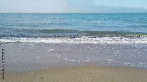 San Francisco, USA - August 2019: Waves in slow motion, washing over the beach on a summer day