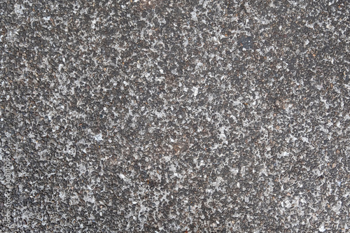 Dark grey asphalt pavement texture with small rocks.
