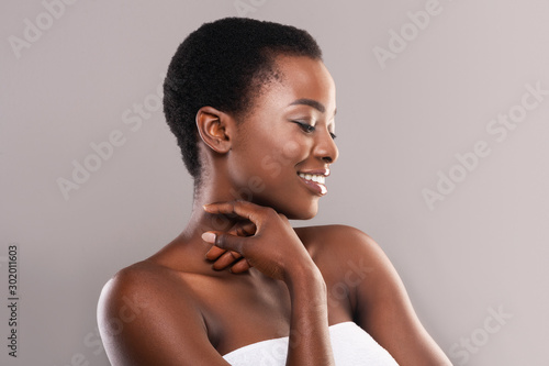 Beautiful black girl touching her velvet skin on neck