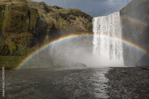 Skogafoss waterfall with a arching rainbow in Iceland