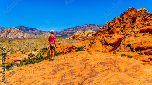 Senior woman hiking on the Red Sandstone Cliffs of the Calico Trail in Red Rock Canyon National Conservation Area near Las Vegas, Nevada, United States