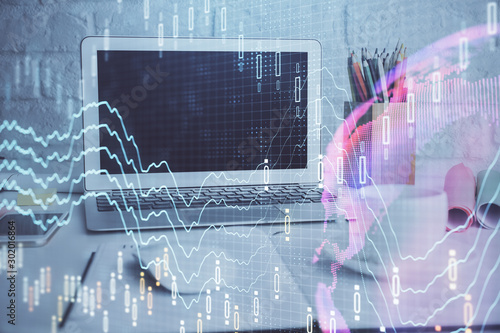 Stock market graph on background with desk and personal computer. Double exposure. Concept of financial analysis.