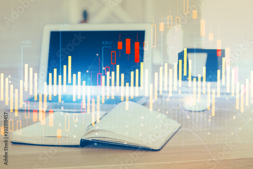 Stock market graph on background with desk and personal computer. Double exposure. Concept of financial analysis. © peshkova