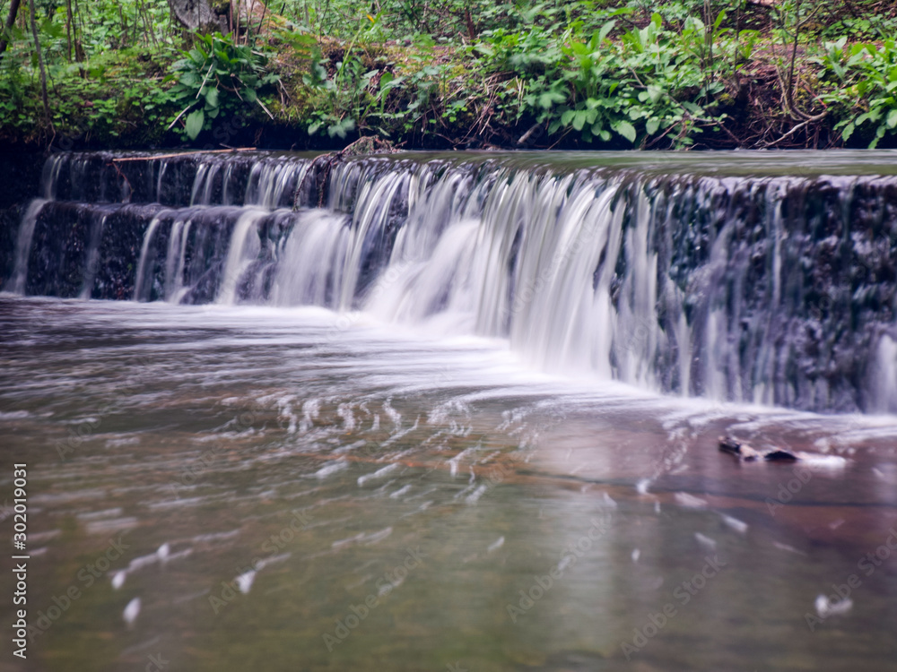 Fototapeta premium landscape with small waterfall (cascade) on river with motion blur.