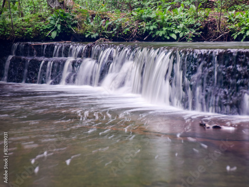 landscape with small waterfall  cascade  on river with motion blur. 