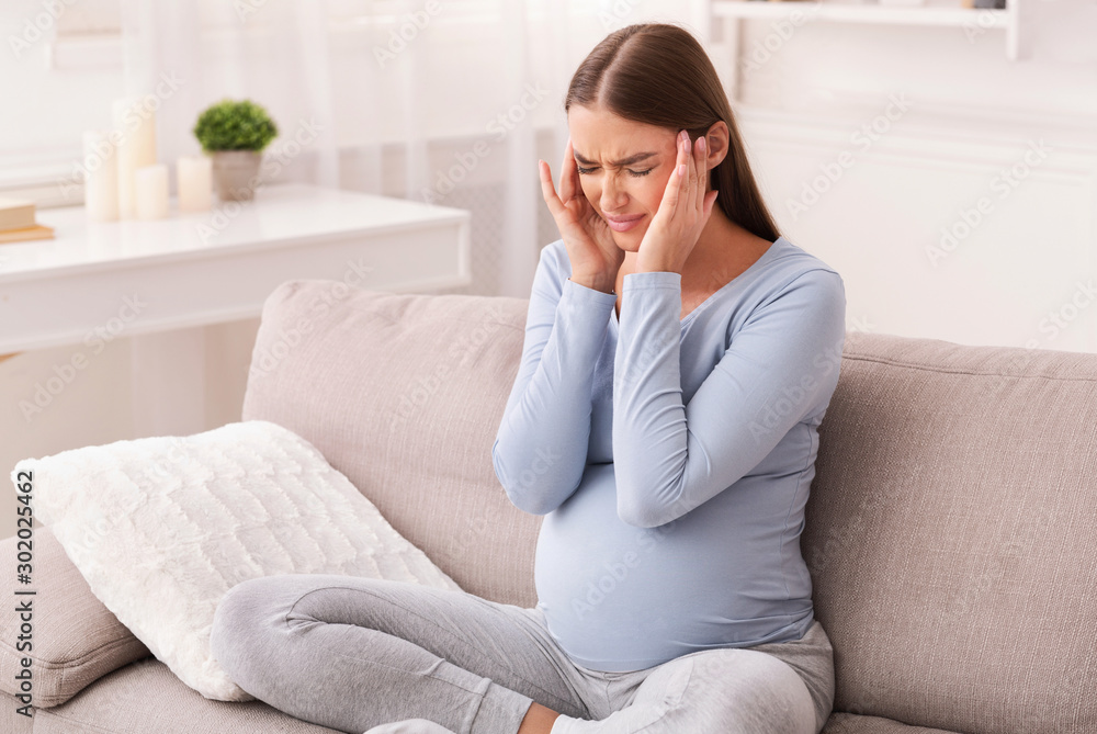 Pregnant Lady Having Migraine Massaging Temples Sitting On Couch Pregnant Lady Having Migraine Massaging Temples Sitting On Couch