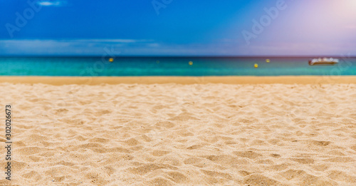 Soft wave of blue ocean on sandy tropical beach. Background of tropical paradise beach with golden sand  travel tourism panorama background concept. Sand and sea waves background.