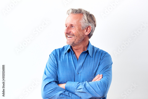 Studio Shot Of Mature Man Against White Background Laughing At Camera