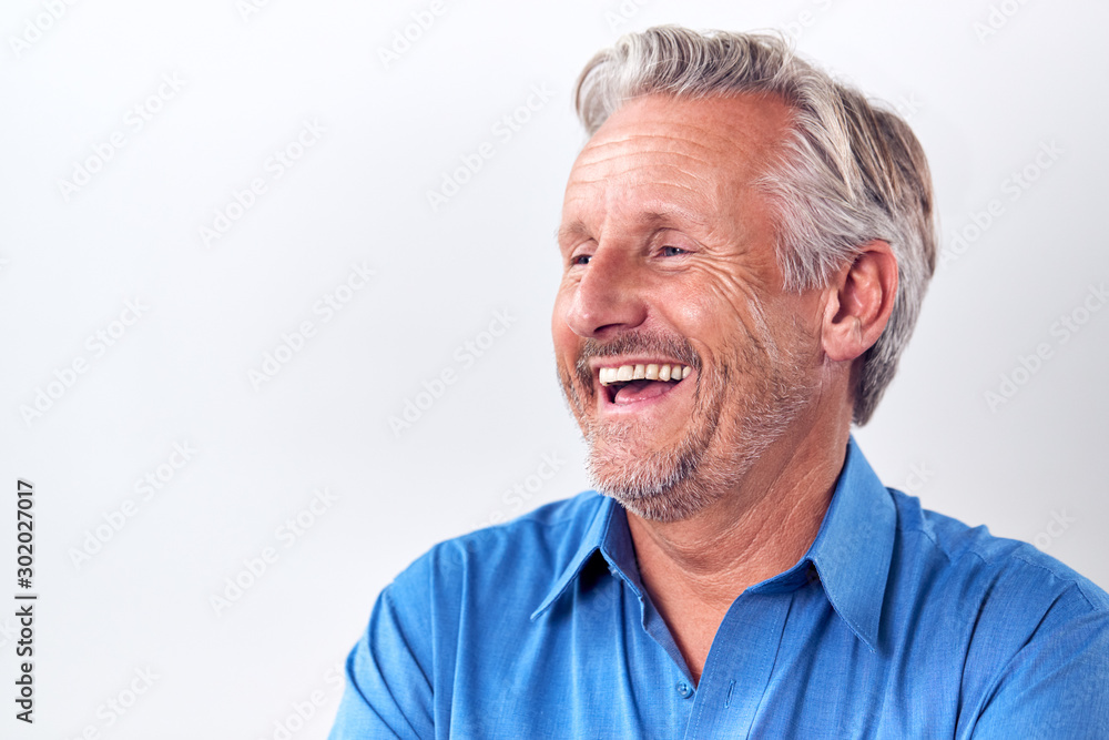 Studio Shot Of Mature Man Against White Background Laughing At Camera Studio Shot Of Mature Man Against White Background Laughing At Camera