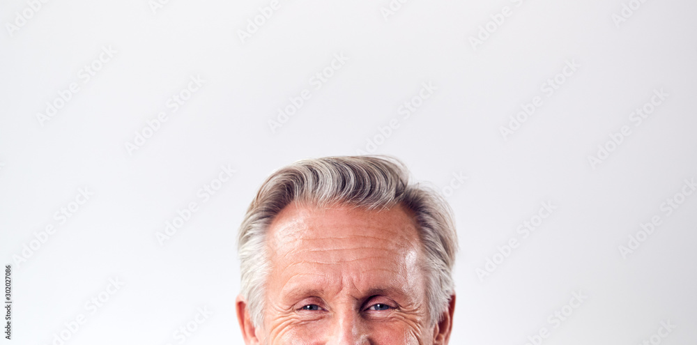 Studio Shot Of Mature Man Against White Background Laughing At Camera Cropped Below Eyes - obrazy, fototapety, plakaty 